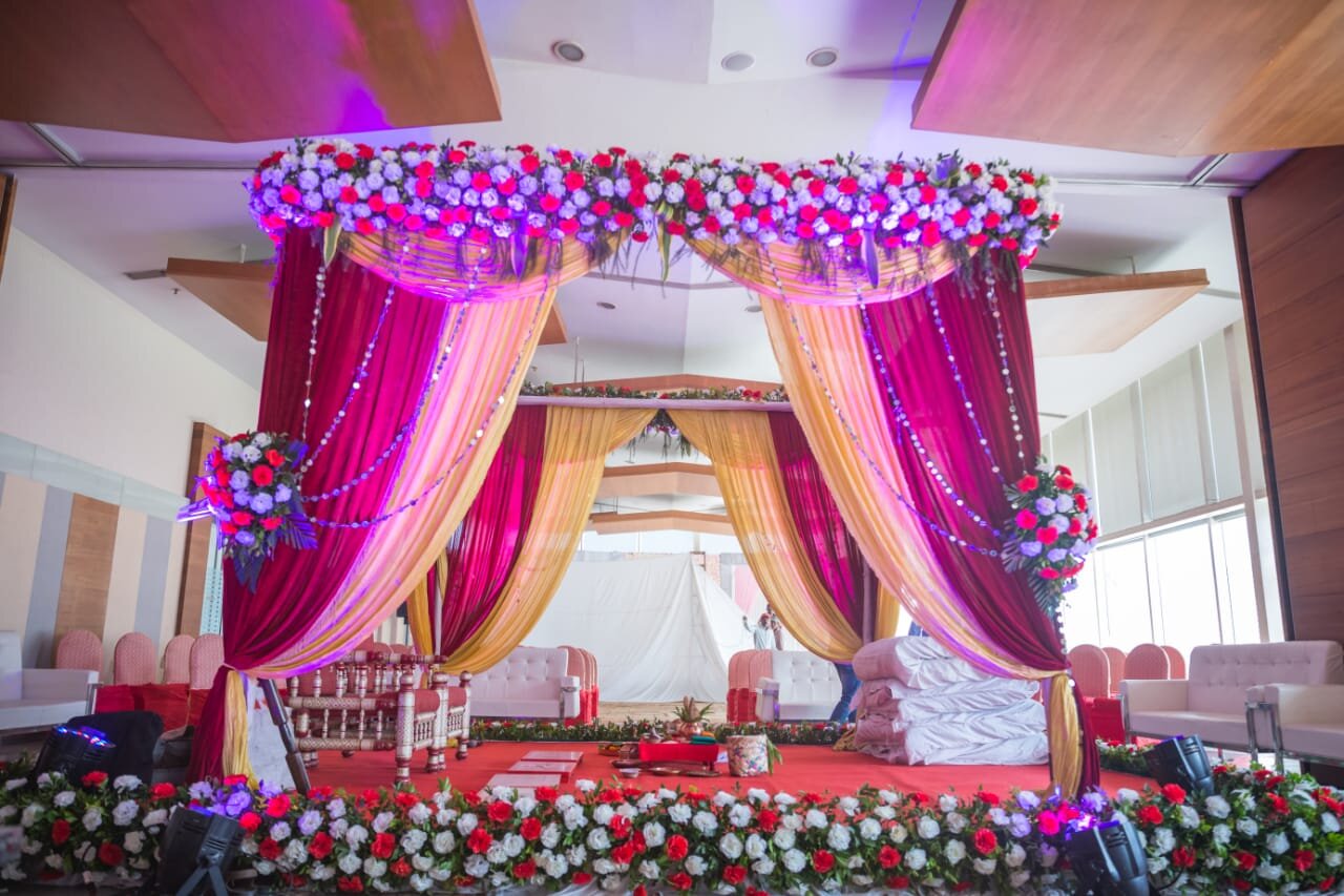 Birthday party floral setup with pink roses and balloon arch