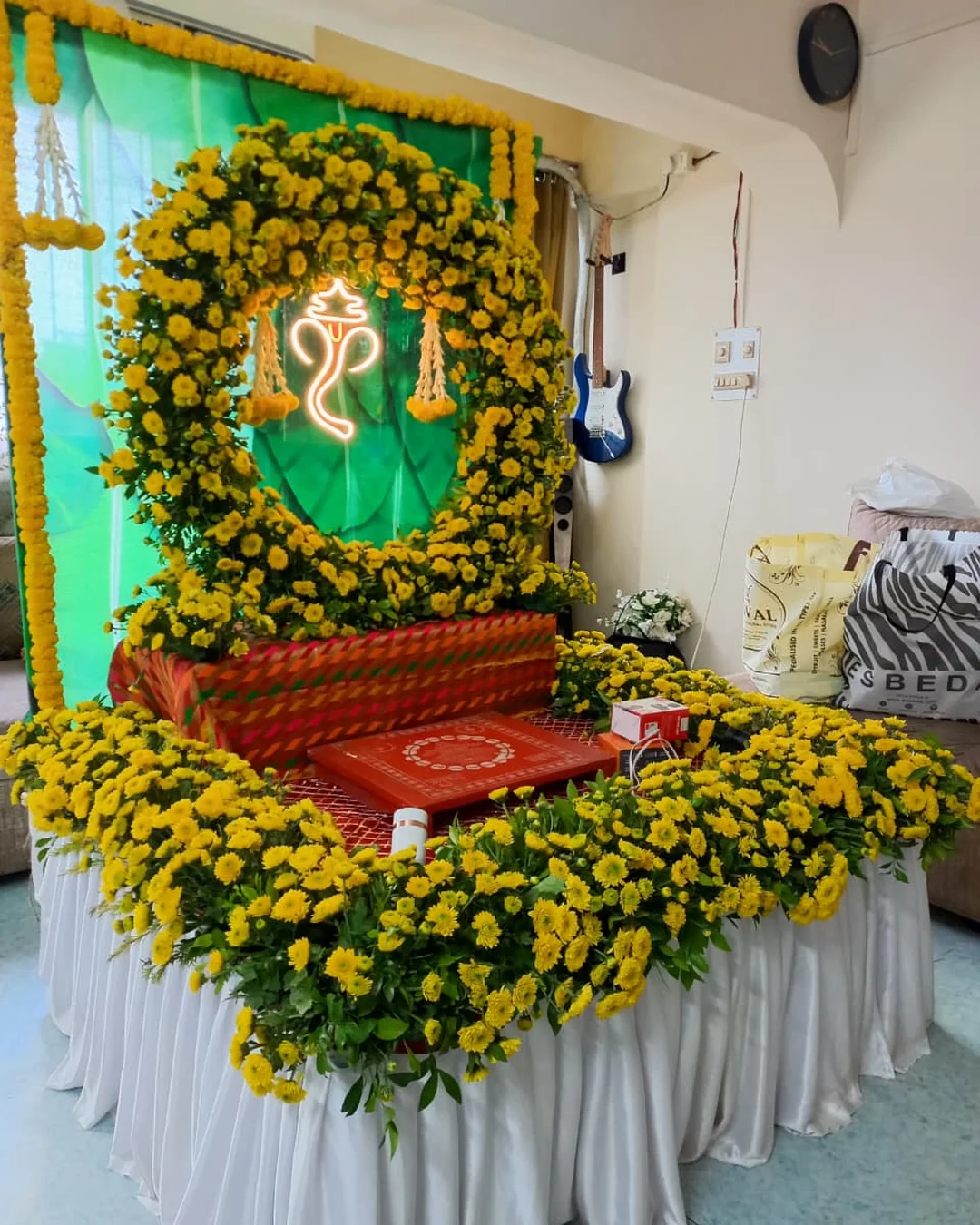 Yellow marigold neon-Ganesha frame on a green banana-leaf backdrop