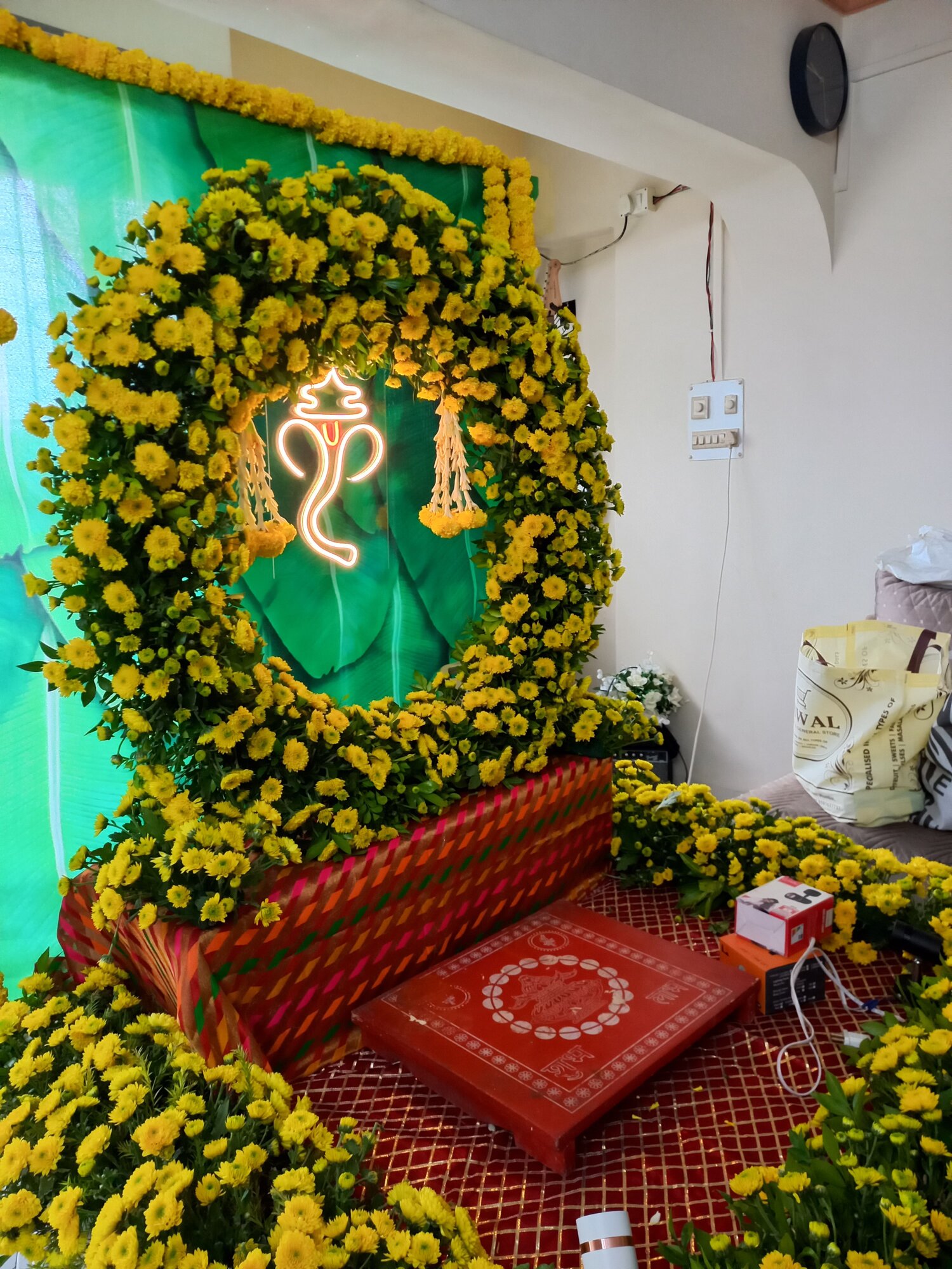 Ganpati decoration with lush green backdrop and fresh flowers