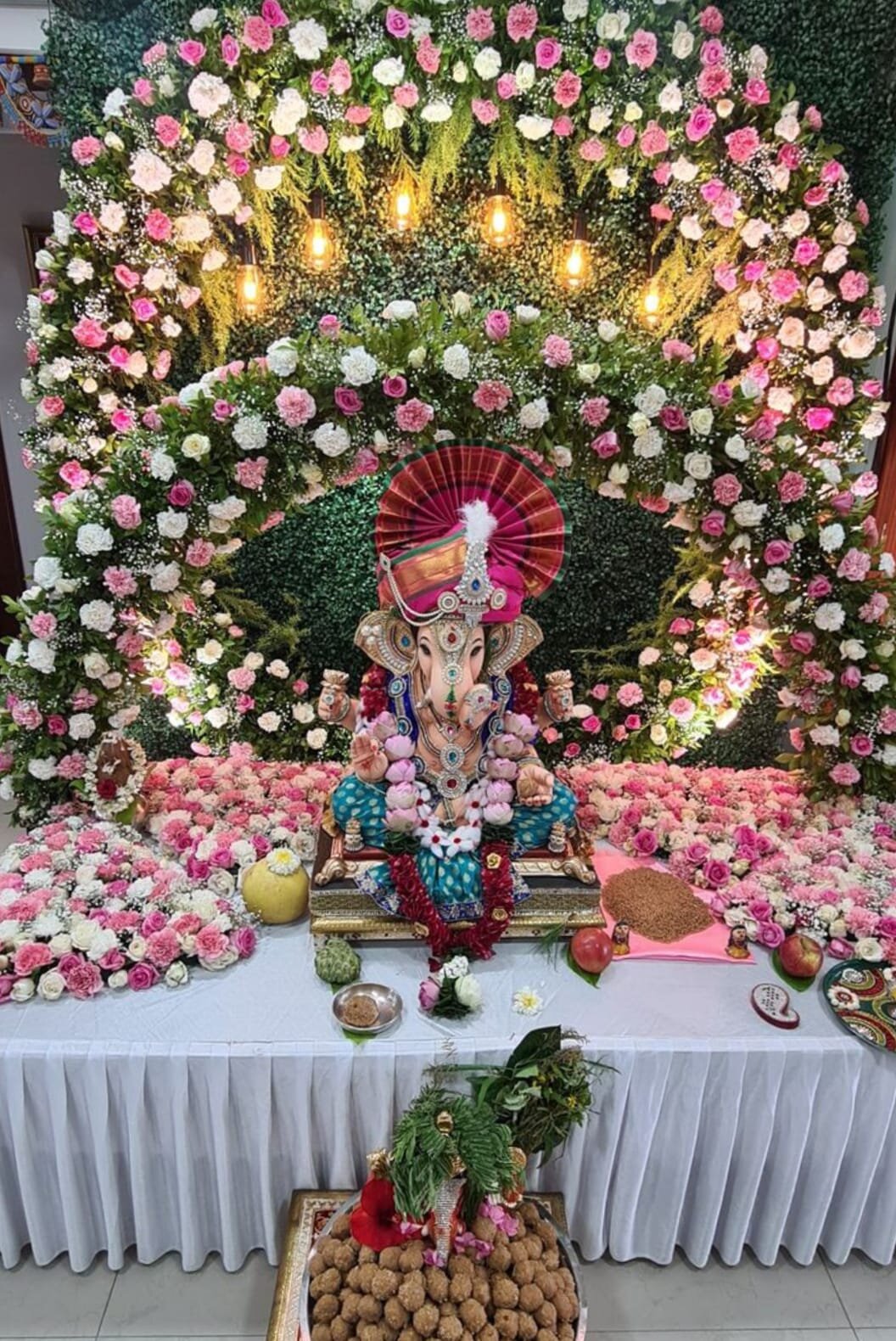 Grand Ganpati decoration with pink carnation flower wall and warm lights